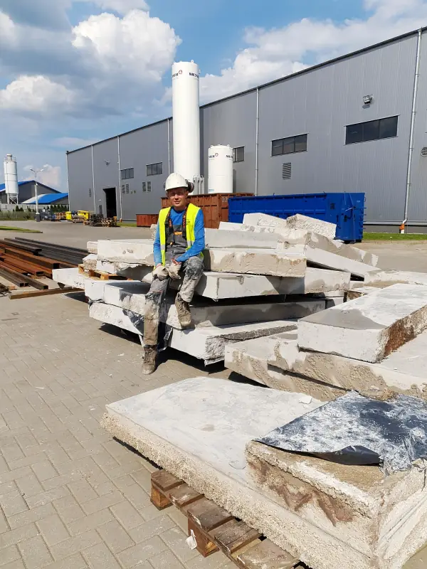 Wycięte płyty posadzki betonowej ułożone na paletach w hali produkcyjnej w Ostródzie